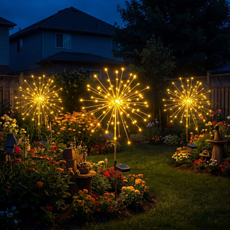Solar starburst garden stake lights glowing in a flower bed