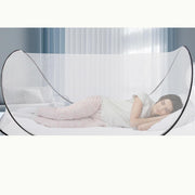 Pop-up mosquito net tent used over a bed for indoor rest