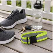 Reflective waist belt beside running shoes and keys