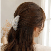 Pearl cream croissant hair claw holding a half-up hairstyle