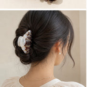 Espresso croissant hair claw holding a low twist updo