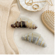 Croissant hair claw clips styled with sweater and vanity accessories
