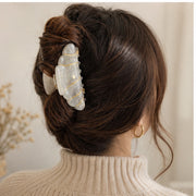 Pearl cream croissant hair claw securing medium-thick hair